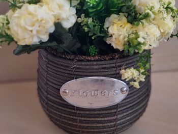 Coş decorativ din ratan, cu flori artificiale crem şi plante verzi